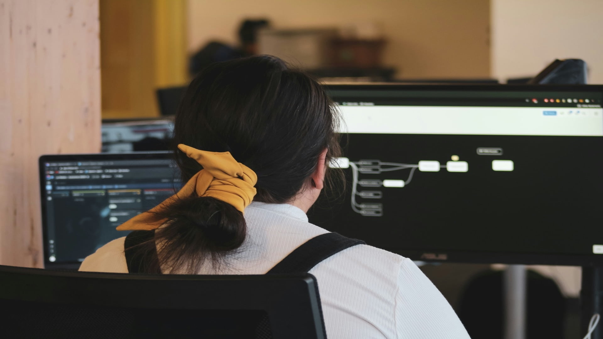 Desarrolladora realizando pruebas de software con múltiples monitores